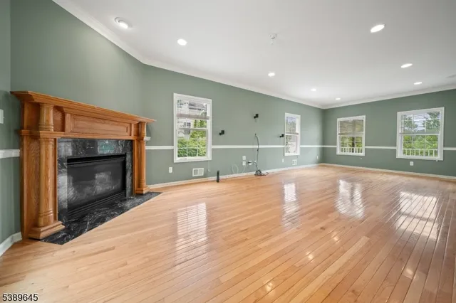 a view of empty room with wooden floor and fireplace