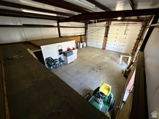 588 North 4500 West West Point, UT 84015 - Photo 44 of 61 Spacious garage featuring concrete flooring, multiple overhead doors, exposed structural beams, and integrated overhead lighting