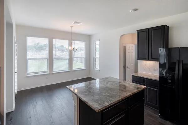 a kitchen with a table chairs refrigerator and window