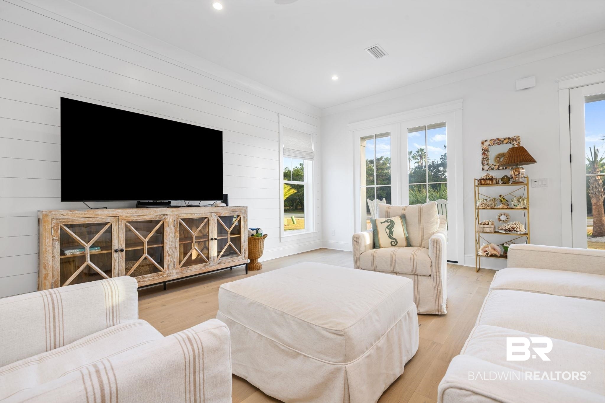 30313 River Road Orange Beach, AL 36561 - Photo 19 of 50 Living room with light wood finished floors, ornamental molding, recessed lighting, and wooden walls