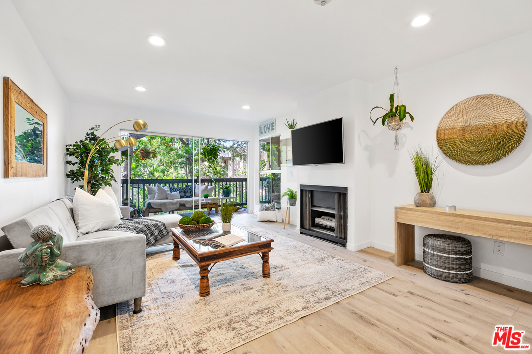 8303 Raintree Circle Culver City, CA 90230 - Photo 2 of 26 a living room with furniture a fireplace and a flat screen tv