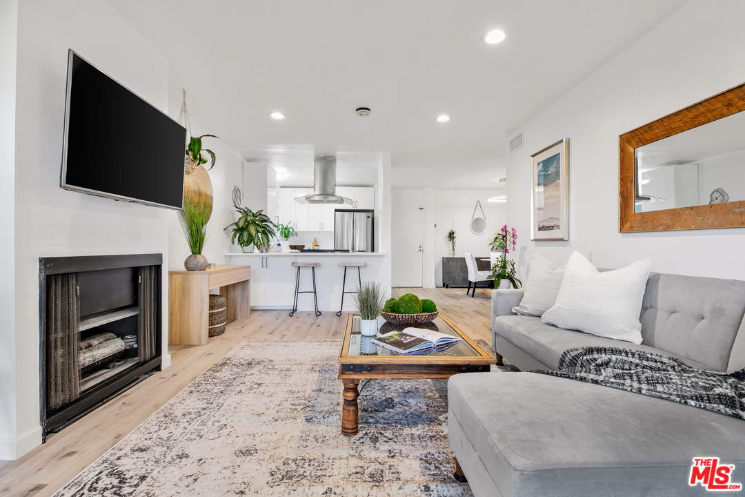 8303 Raintree Circle Culver City, CA 90230 - Photo 5 of 26 a living room with furniture a flat screen tv and a fireplace