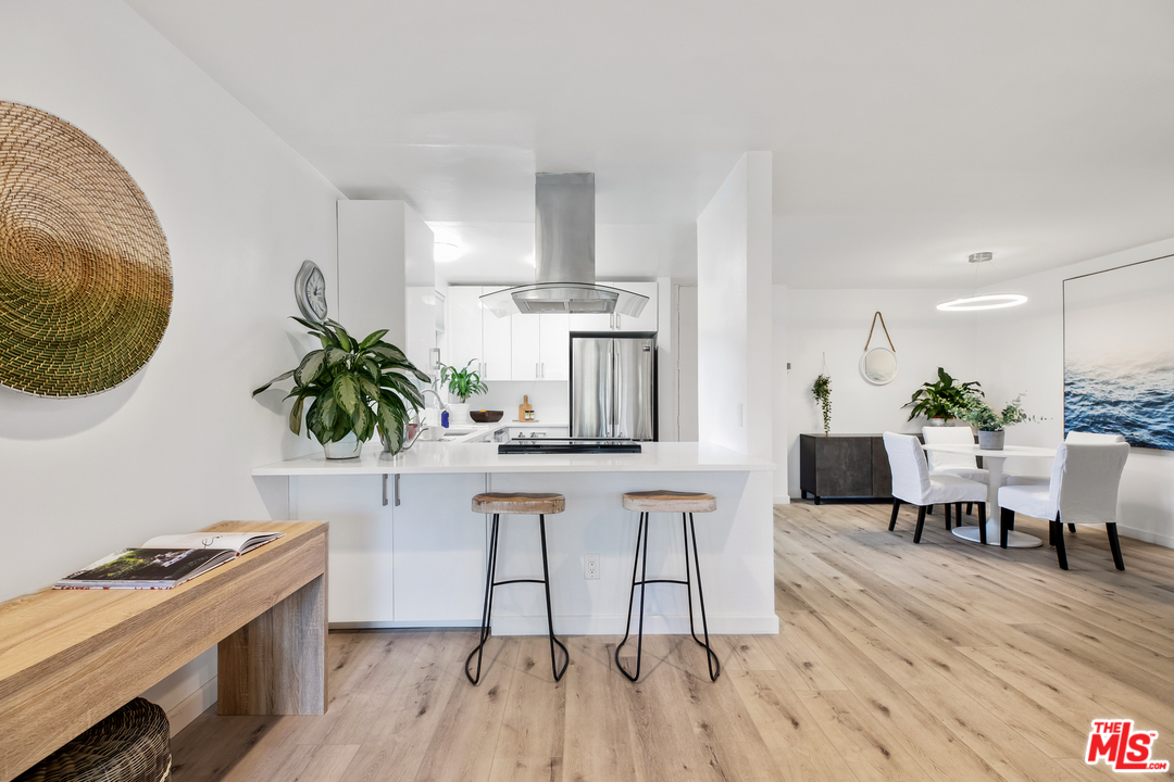 8303 Raintree Circle Culver City, CA 90230 - Photo 7 of 26 a kitchen with stainless steel appliances granite countertop a table and chairs in it