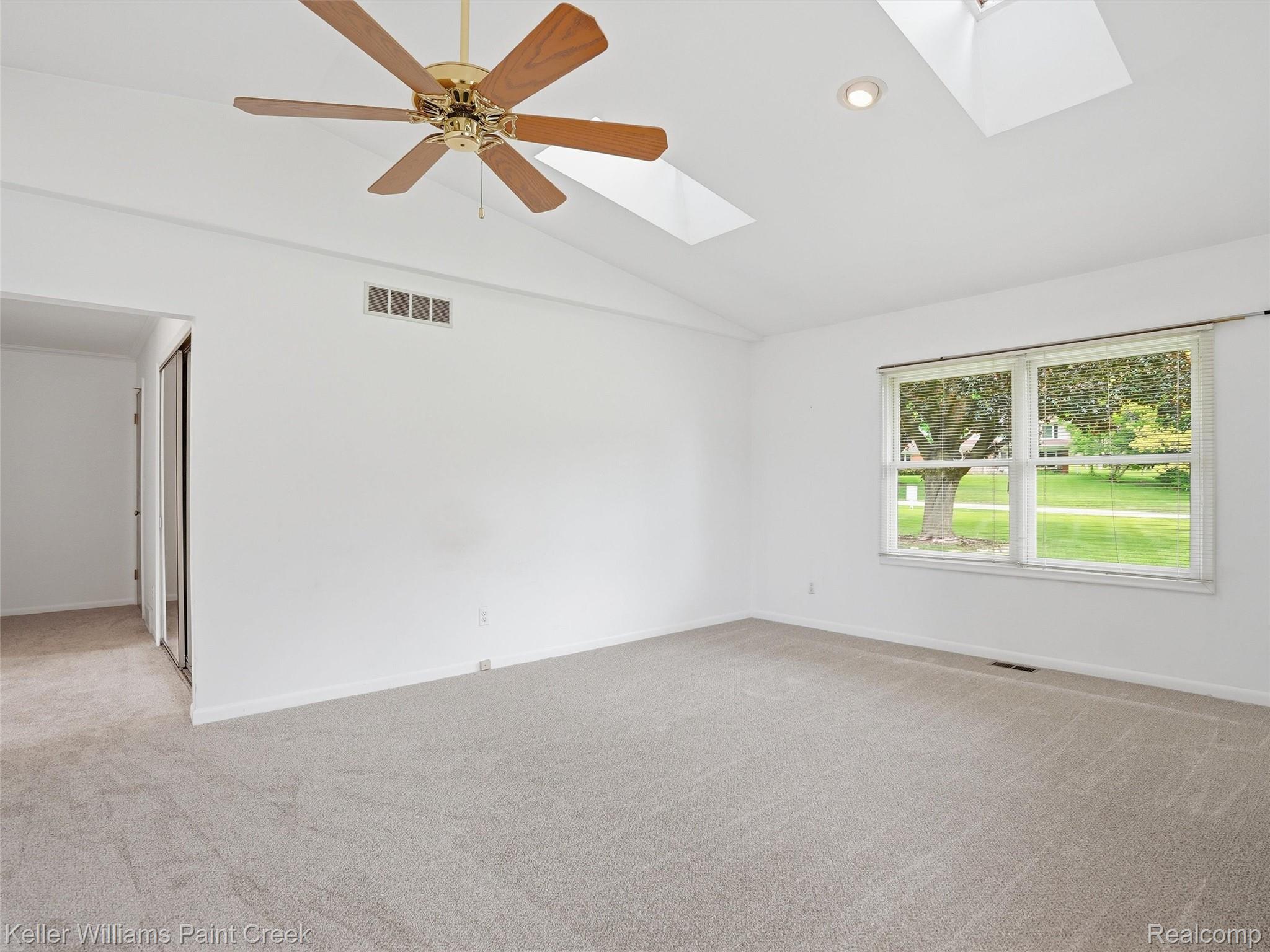 436 Broadleaf Drive Rochester, MI 48306 - Photo 23 of 41 Unfurnished room featuring a ceiling fan, a skylight, vaulted ceiling, light carpet, and recessed lighting