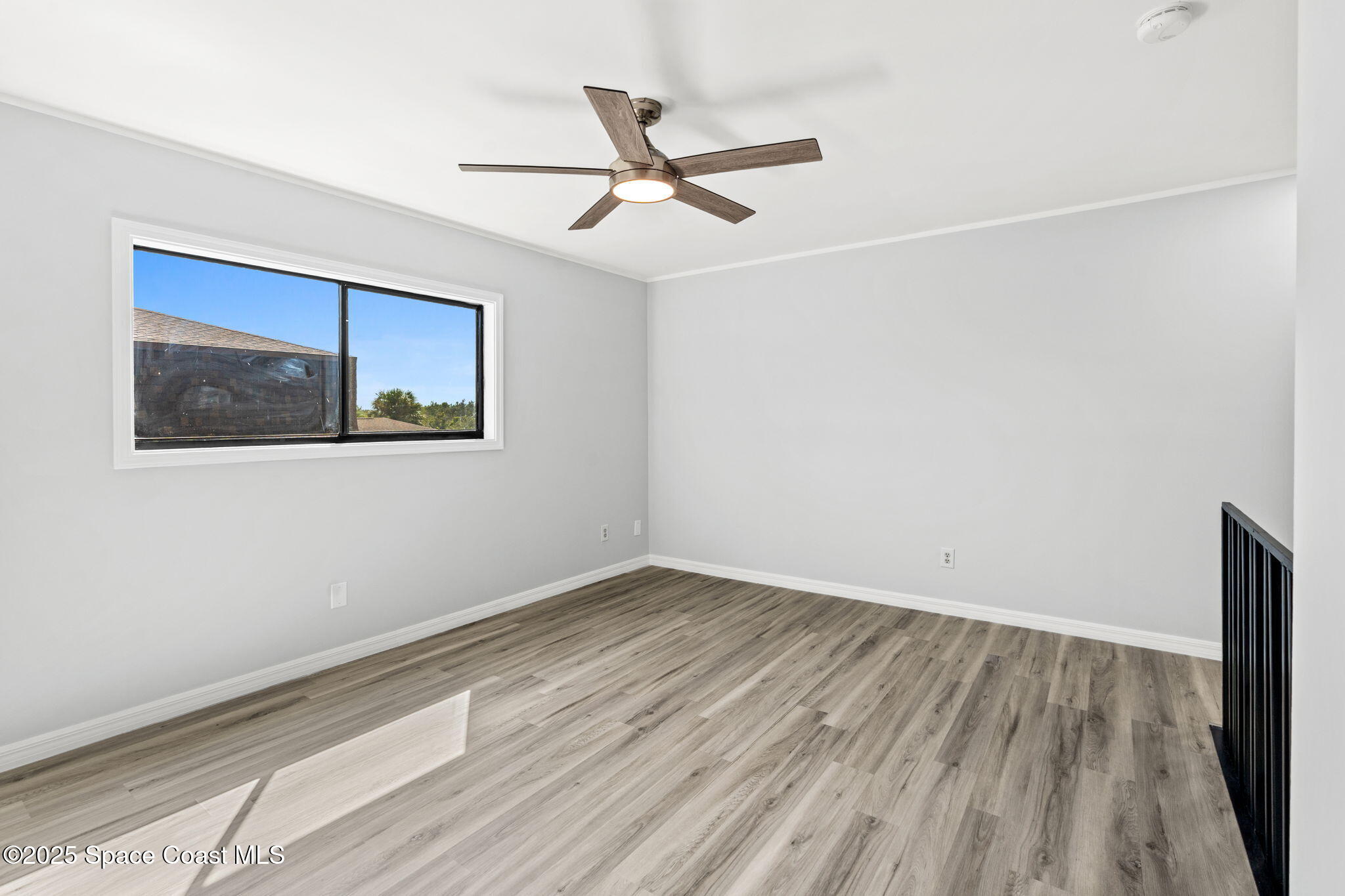 3316 Overlook Drive, Unit 62 Palm Bay, FL 32905 - Photo 13 of 23 an empty room with wooden floor and ceiling fan