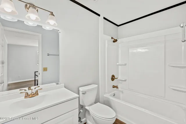 a bathroom with a sink a toilet a mirror a vanity and shower
