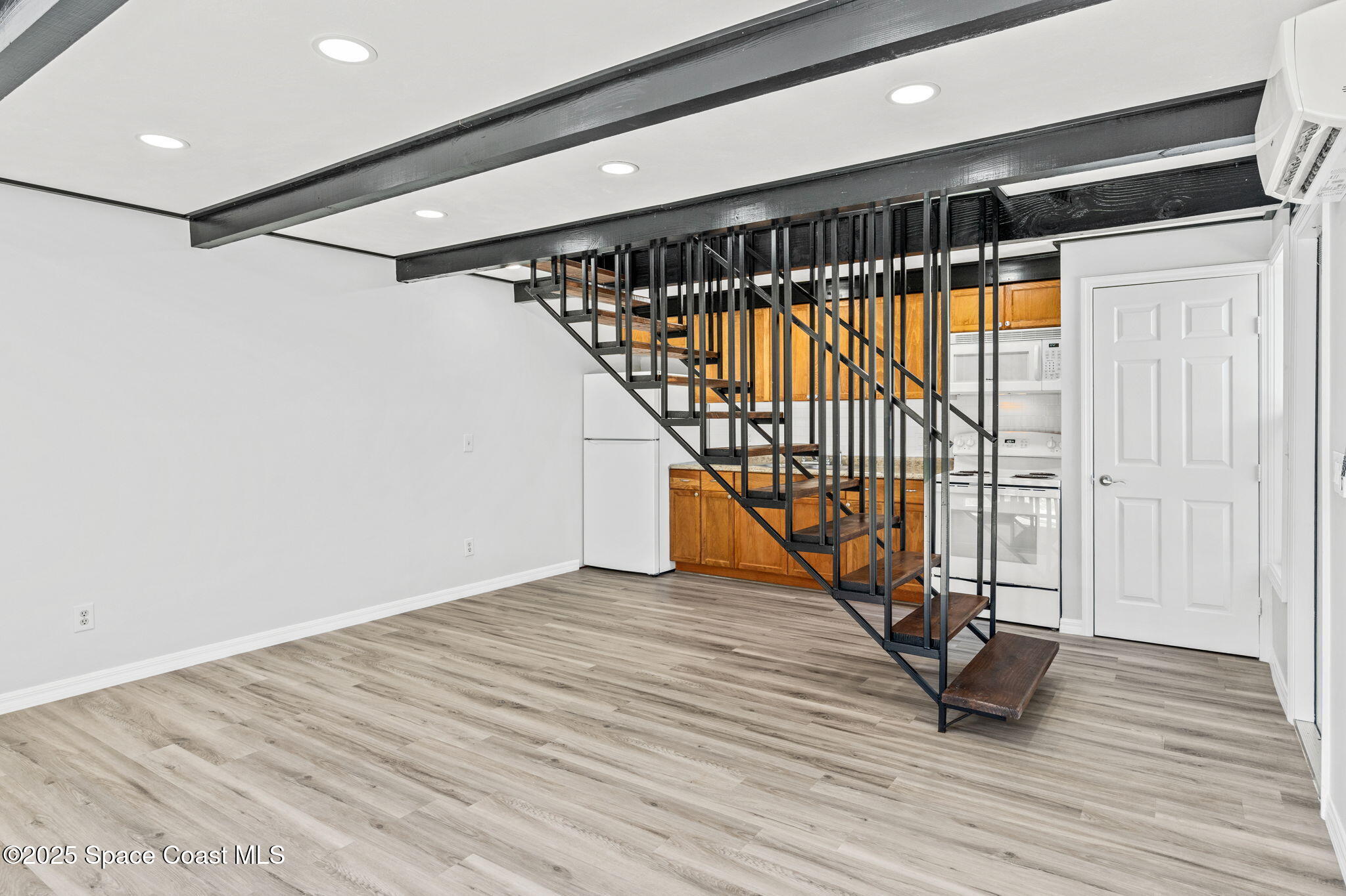3316 Overlook Drive, Unit 62 Palm Bay, FL 32905 - Photo 7 of 23 a view of an empty room with wooden floor and stairs