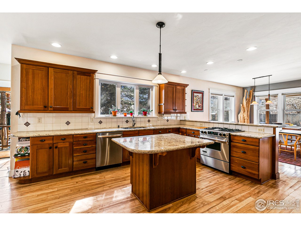 2853 14th Street Boulder, CO 80304 - Photo 11 of 40 a large kitchen with stainless steel appliances granite countertop a stove a sink dishwasher and cabinets with wooden floor