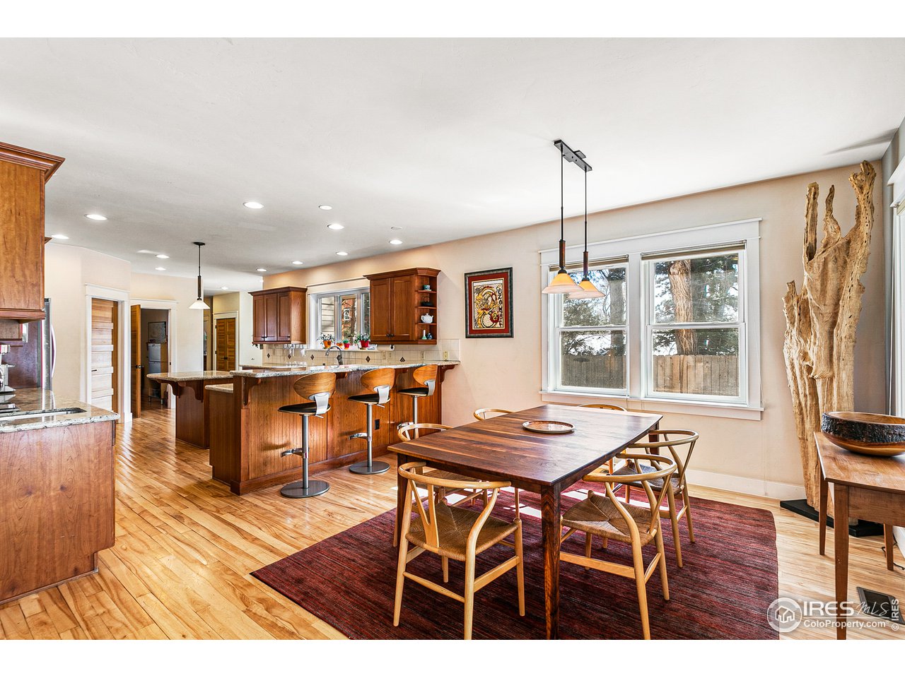 2853 14th Street Boulder, CO 80304 - Photo 9 of 40 a open kitchen with stainless steel appliances kitchen island granite countertop a dining table chairs and stove top oven with wooden floor