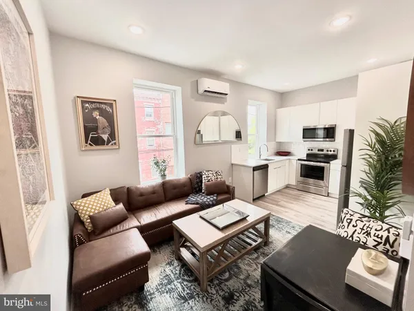 a living room with furniture rug and flat screen tv