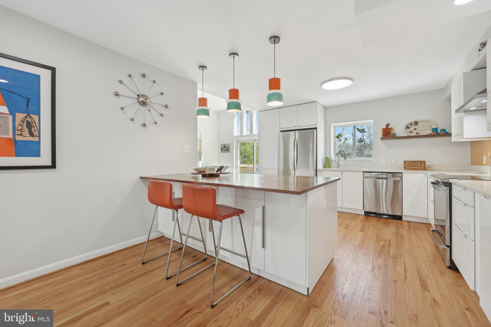 1503 Inlet Court Reston, VA 20190 - Photo 14 of 59 a living room with kitchen island stainless steel appliances furniture a rug and a kitchen view