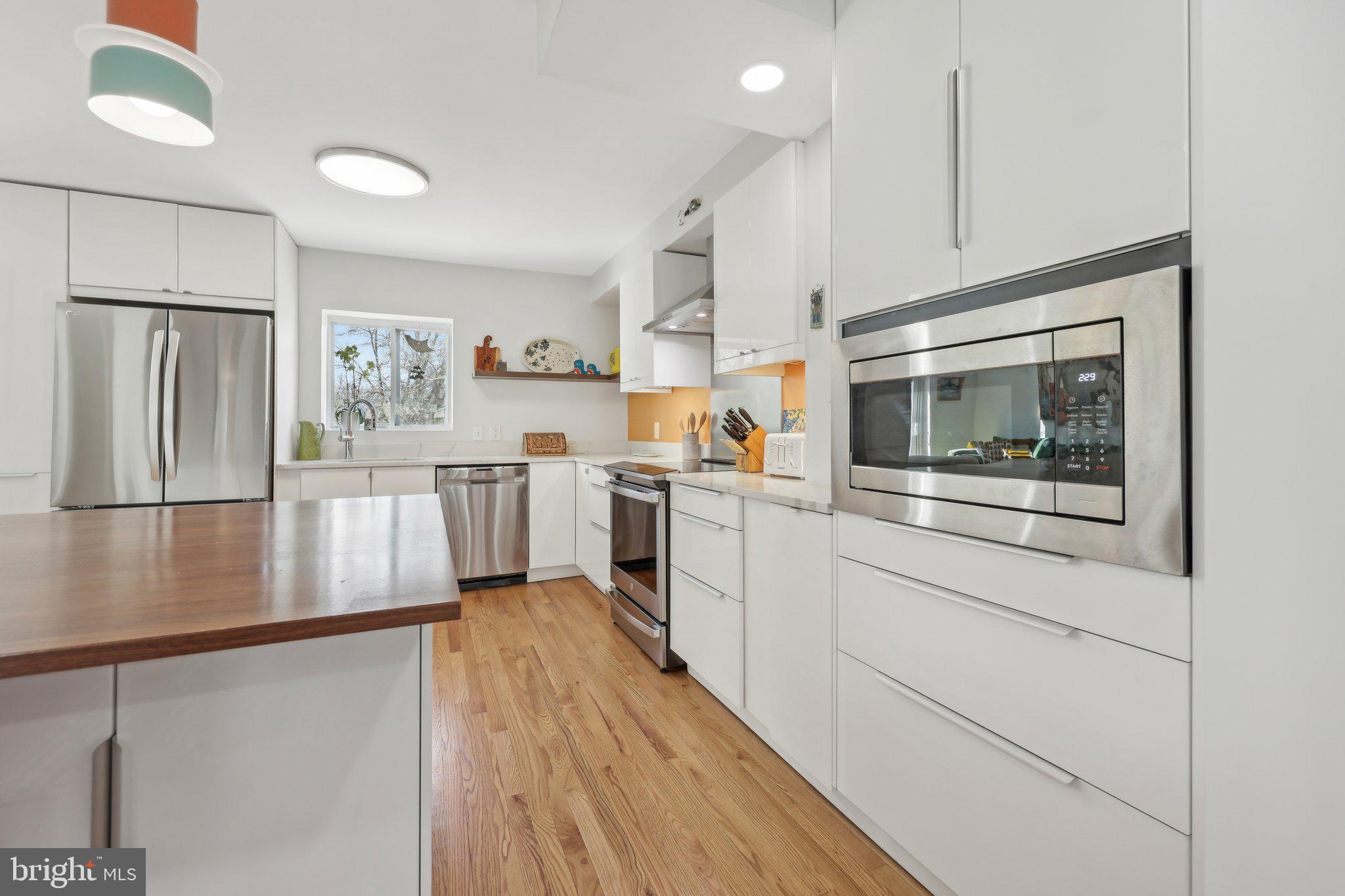 1503 Inlet Court Reston, VA 20190 - Photo 15 of 59 a kitchen with stainless steel appliances a stove a microwave and white cabinets