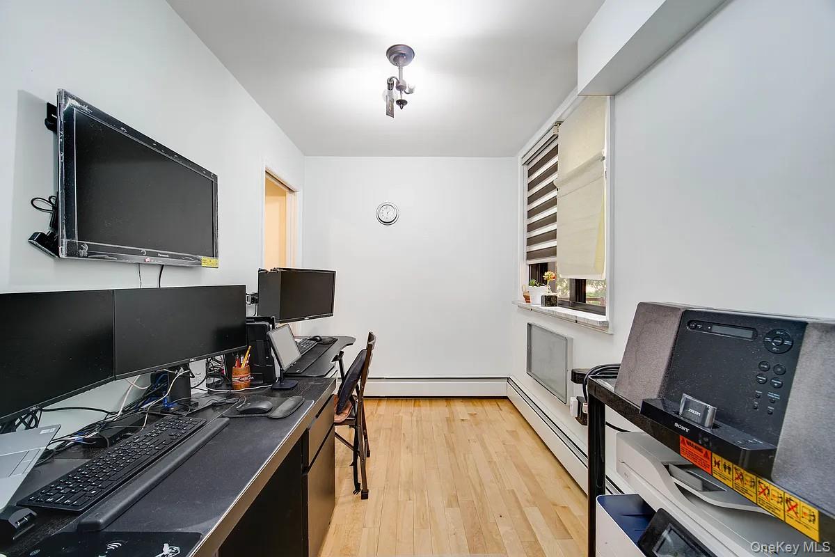 99-05 59th Avenue, Unit 2A Queens, NY 11368 - Photo 9 of 14 a view of a workspace with furniture and a flat screen tv
