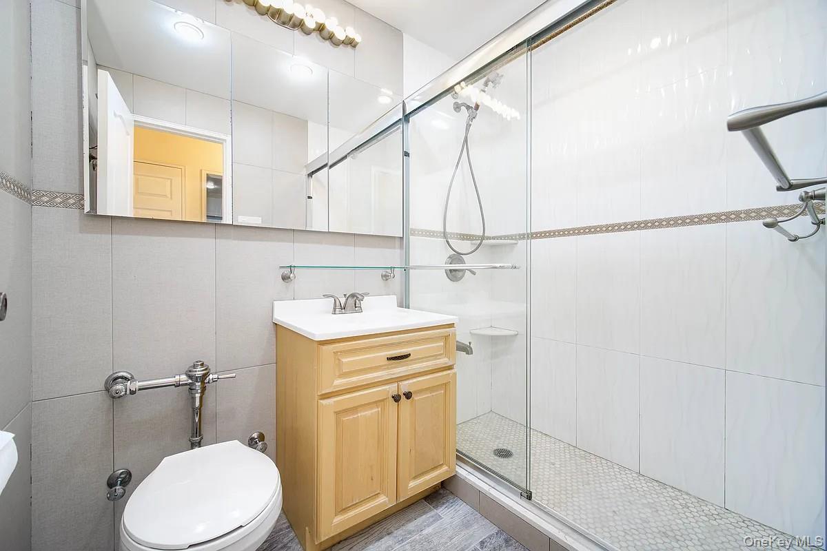 99-05 59th Avenue, Unit 2A Queens, NY 11368 - Photo 10 of 14 a bathroom with a sink a toilet and mirror