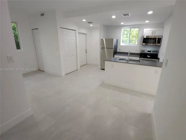 a view of kitchen with refrigerator stove and a sink