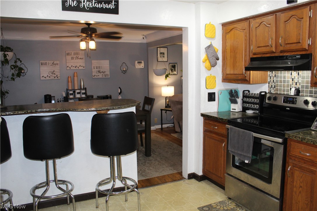 1292 Ford Road Lyndhurst, OH 44124 - Photo 3 of 25 Kitchen featuring electric range, a breakfast bar area, and light vinyl floors