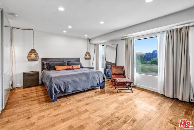 a bedroom with a bed and wooden floor