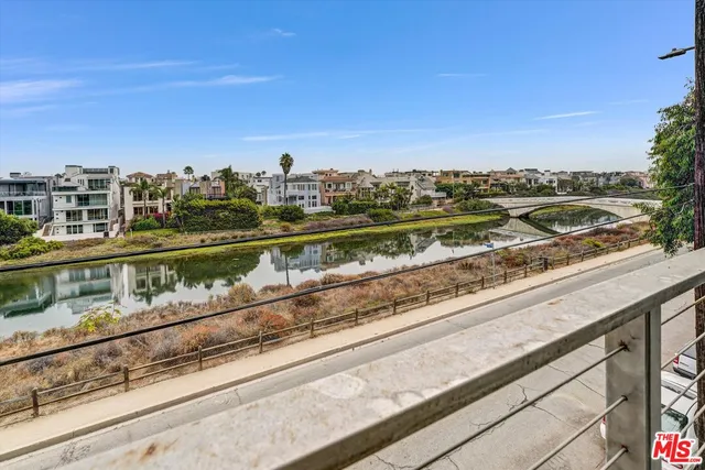 a view of a city from a balcony with seating space