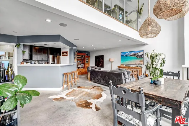 a living room with furniture a chandelier and kitchen view