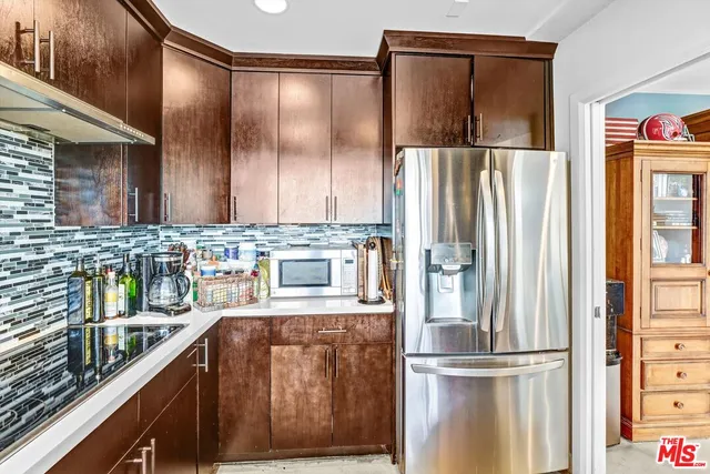 a kitchen with stainless steel appliances granite countertop a refrigerator and a sink