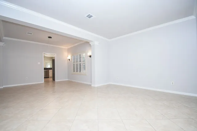 a view of a livingroom with a fireplace a ceiling fan and windows