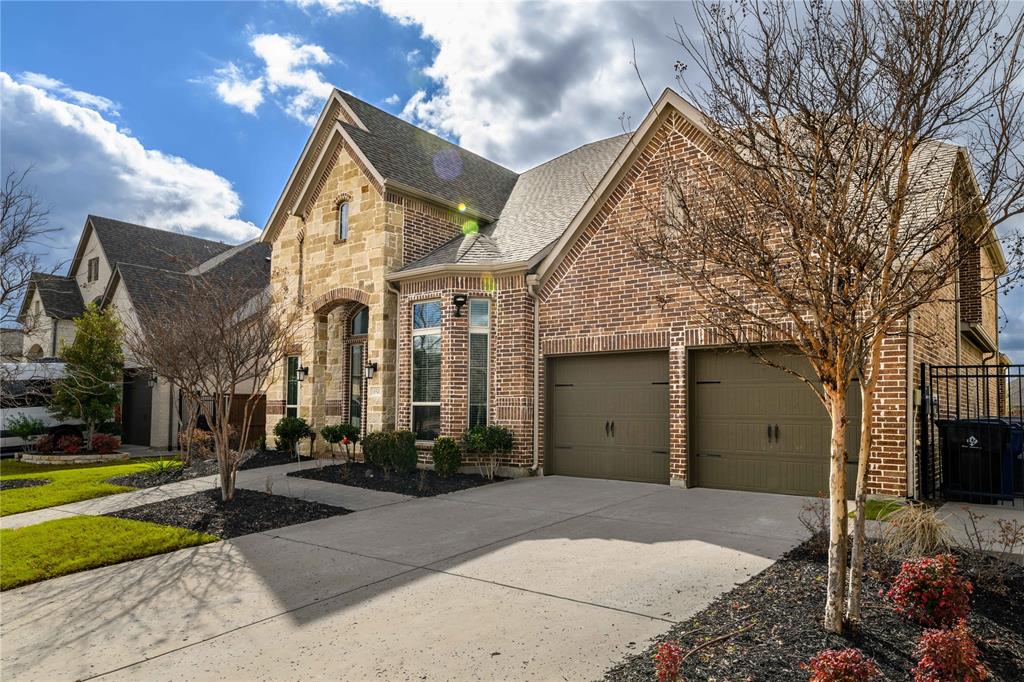 16541 Sweetgum Road Frisco, TX 75033 - Photo 1 of 28 French country style house featuring driveway, brick siding, a garage, roof with shingles, and stone siding