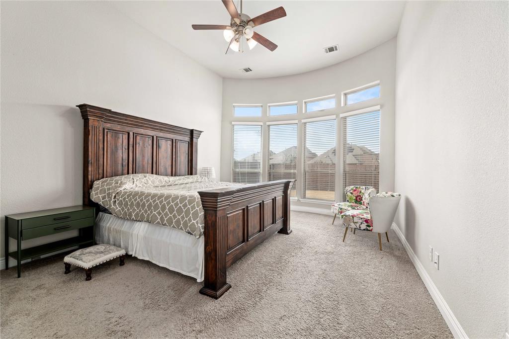 16541 Sweetgum Road Frisco, TX 75033 - Photo 16 of 28 Bedroom with light carpet, ceiling fan, a high ceiling, and a textured wall
