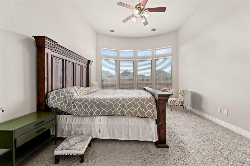 16541 Sweetgum Road Frisco, TX 75033 - Photo 16 of 28 a bedroom with a bed and a chandelier