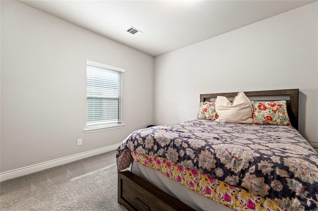 16541 Sweetgum Road Frisco, TX 75033 - Photo 22 of 28 Bedroom with light colored carpet and baseboards
