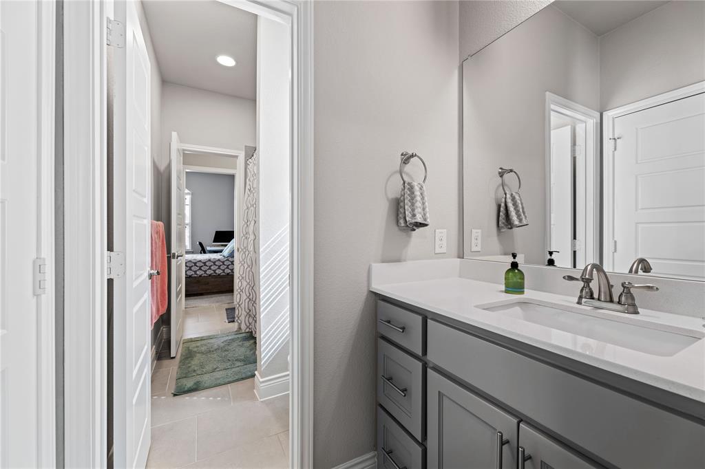 16541 Sweetgum Road Frisco, TX 75033 - Photo 23 of 28 Bathroom featuring vanity, light tile patterned flooring, and connected bathroom