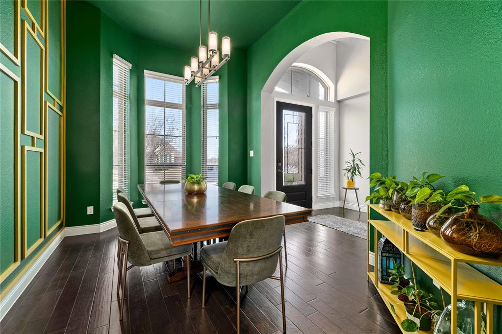 16541 Sweetgum Road Frisco, TX 75033 - Photo 3 of 28 Dining room featuring suspended lighting, dark wood-style floors, plenty of natural light, and arched walkways