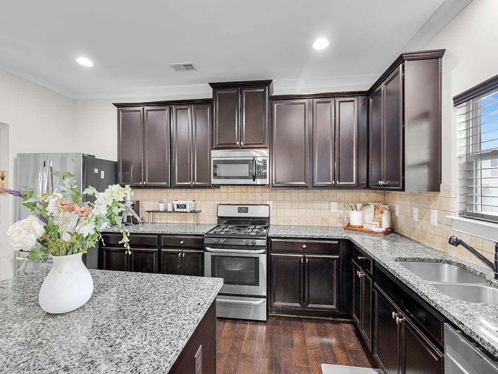 5110 Rialto Way Cumming, GA 30040 - Photo 12 of 50 a kitchen with stainless steel appliances granite countertop a sink stove and refrigerator