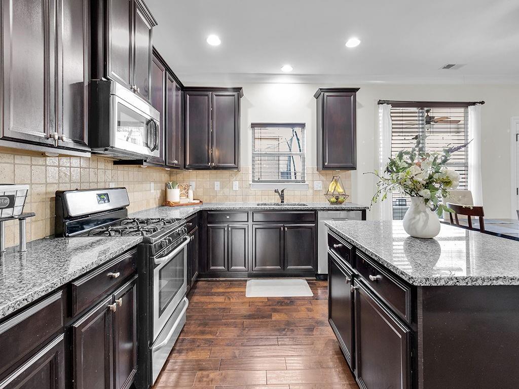 5110 Rialto Way Cumming, GA 30040 - Photo 15 of 50 a kitchen with stainless steel appliances granite countertop a sink stove and refrigerator