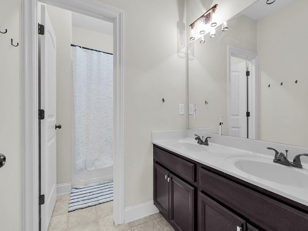 5110 Rialto Way Cumming, GA 30040 - Photo 28 of 50 a bathroom with a double vanity sink a mirror and a shower