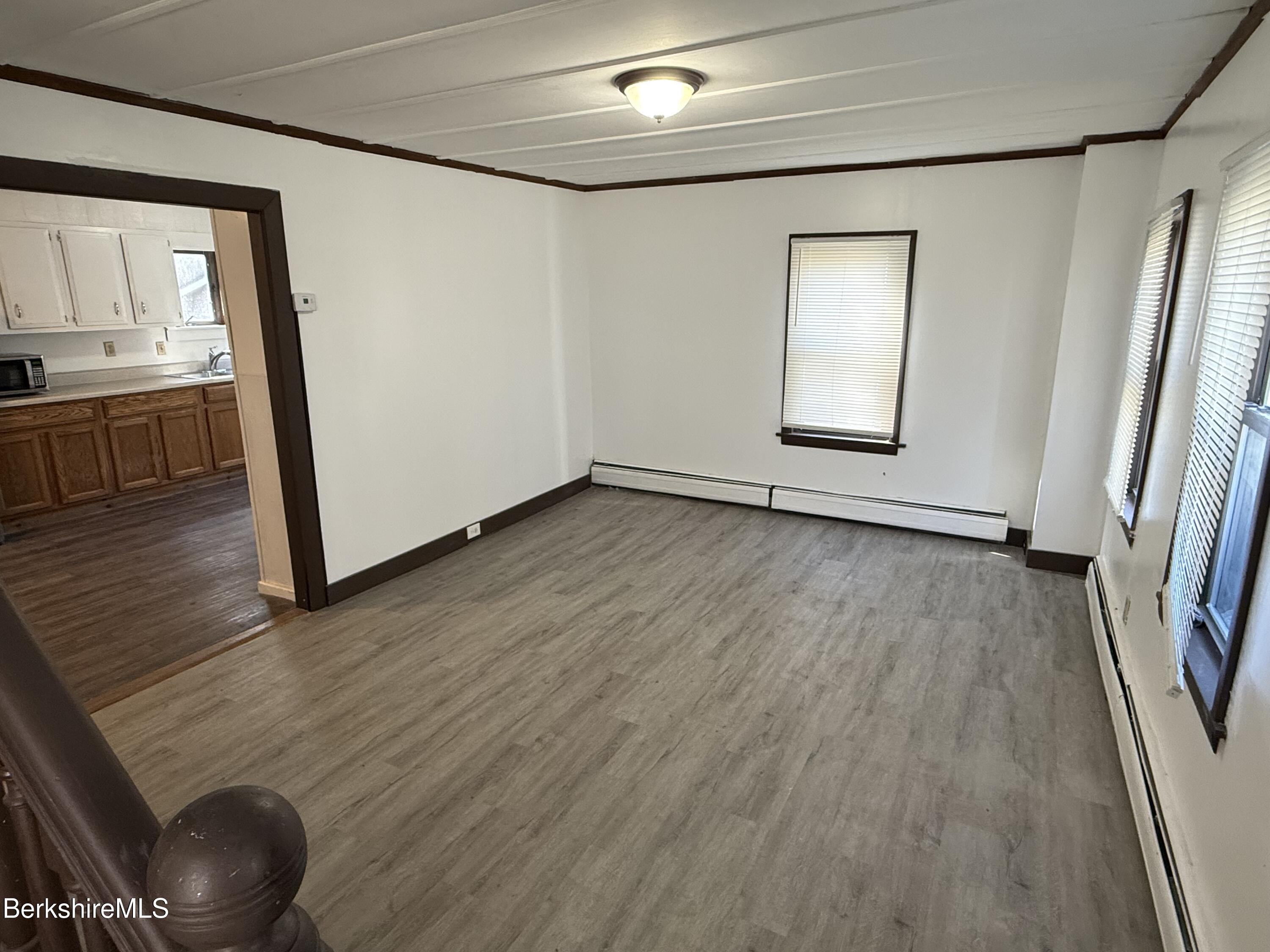 130 Commercial Street, Unit 1 Adams, MA 01220 - Photo 4 of 7 a view of an empty room with wooden floor and a window