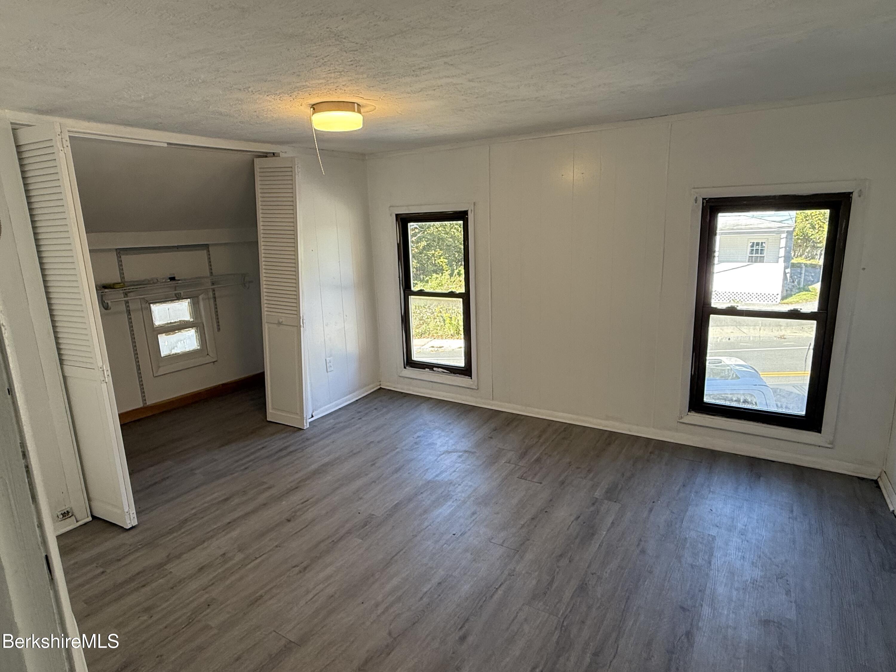 130 Commercial Street, Unit 1 Adams, MA 01220 - Photo 5 of 7 an empty room with wooden floor and windows