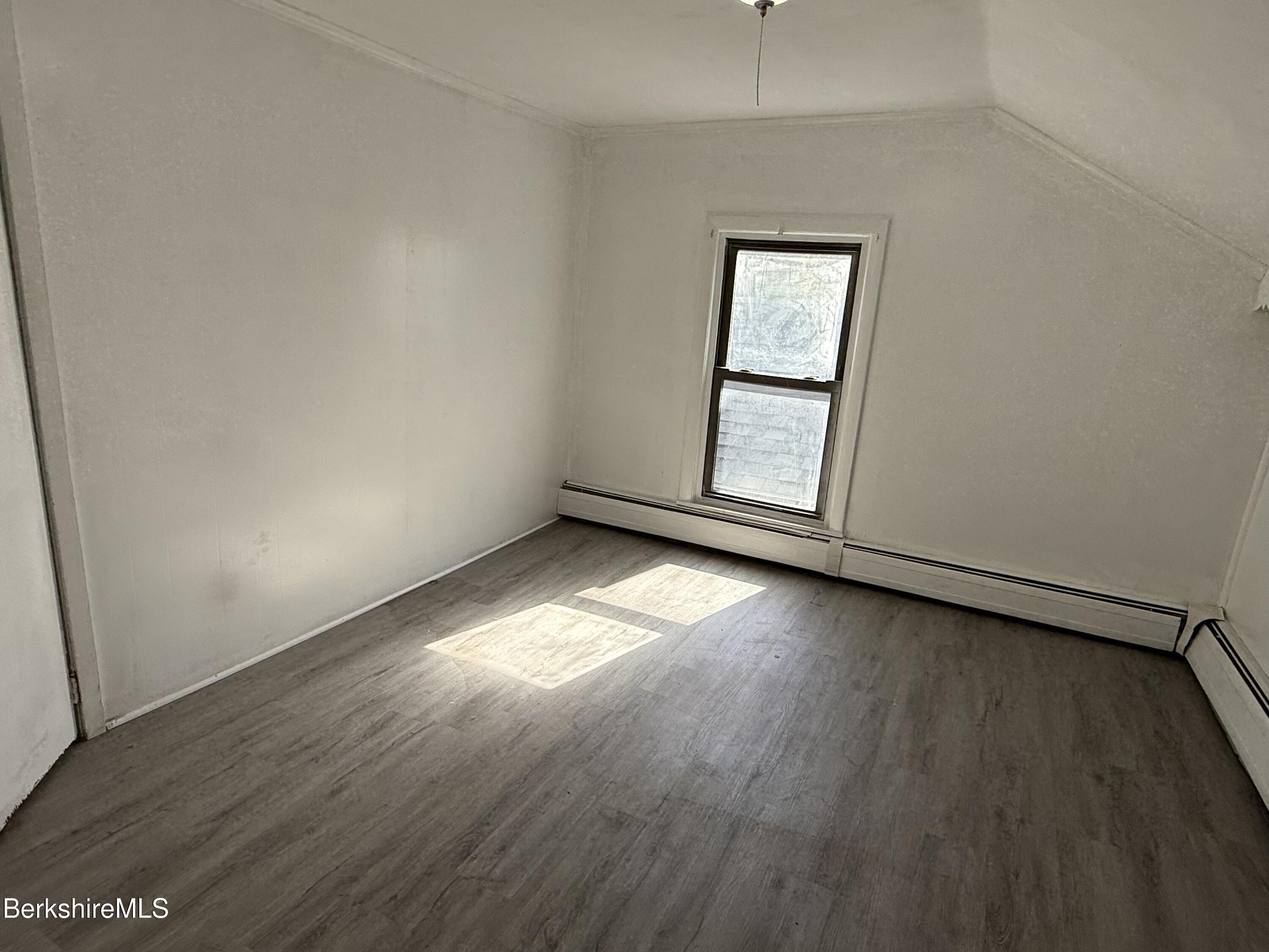 130 Commercial Street, Unit 1 Adams, MA 01220 - Photo 6 of 7 an empty room with wooden floor and windows