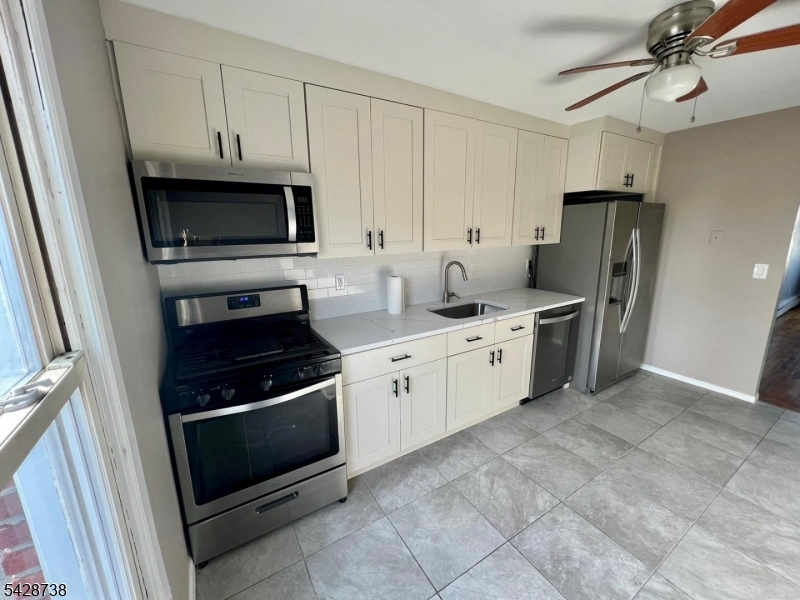 26 Clinton Street, Unit 9 Belleville, NJ 07109 - Photo 5 of 6 a kitchen with stainless steel appliances granite countertop a refrigerator stove and sink