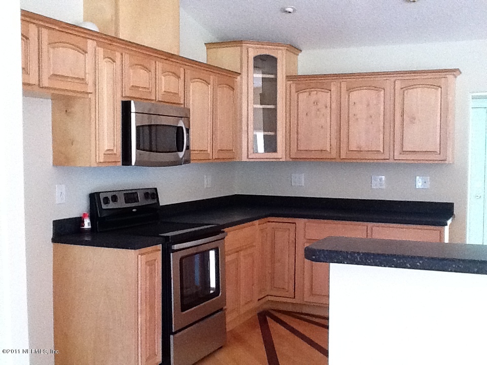 4130 Appaloosa Road Middleburg, FL 32068 - Photo 6 of 15 a kitchen with stainless steel appliances granite countertop a stove microwave and cabinets