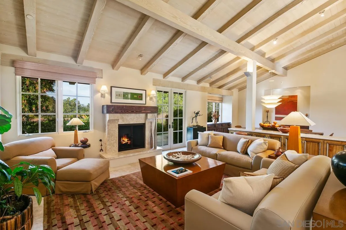 a living room with furniture fireplace and a large window