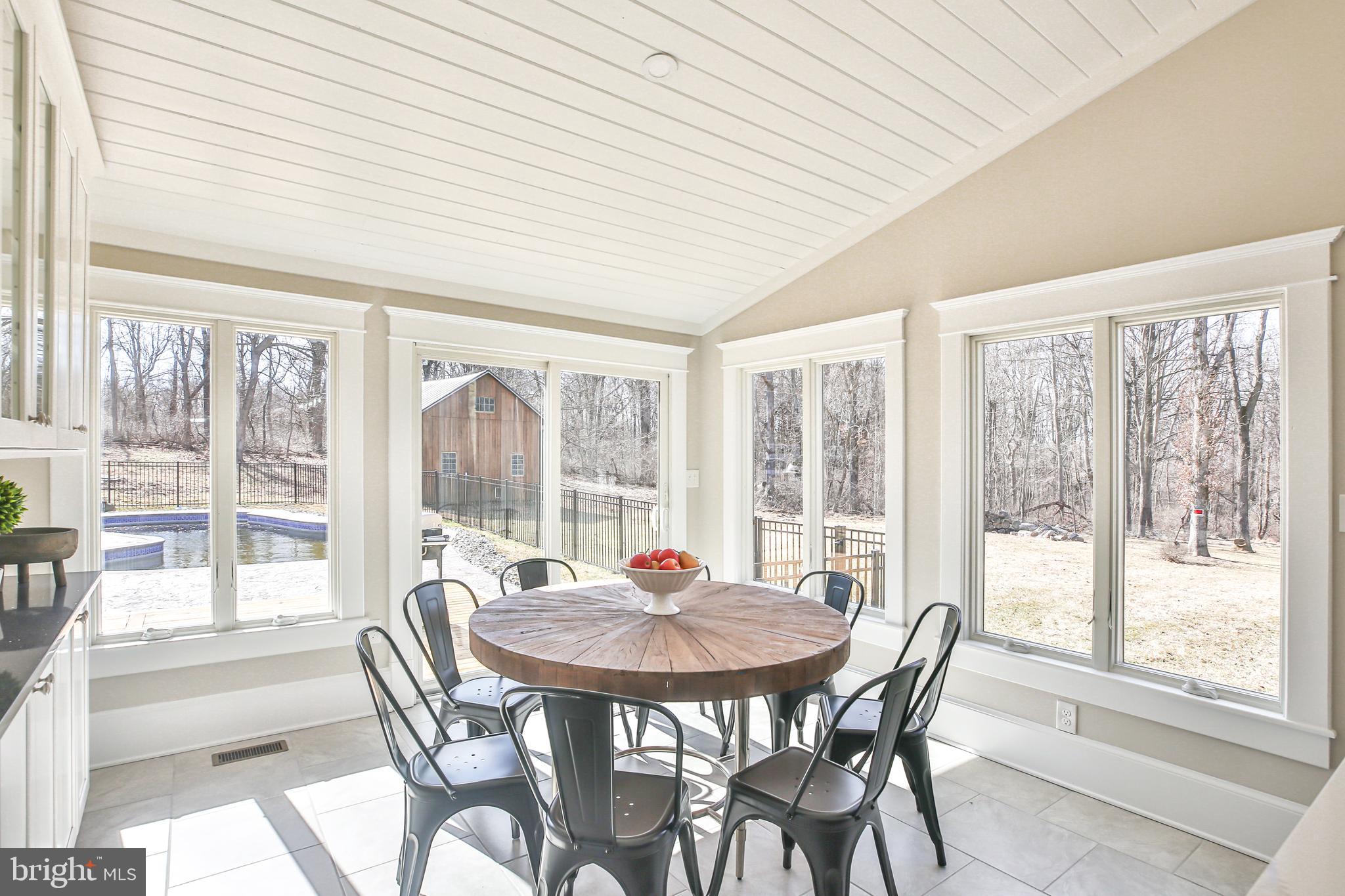 17345 Raven Rocks Road Bluemont, VA 20135 - Photo 36 of 99 a dining room with furniture large windows and wooden floor