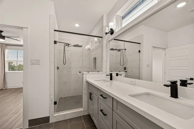 a bathroom with double vanity and a shower
