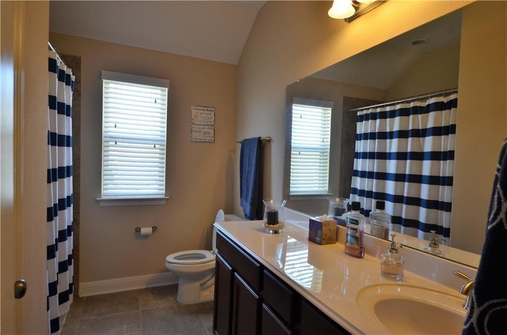 5629 Rio Chama Cove Austin, TX 78738 - Photo 19 of 34 A well-lit bathroom features a single vanity, a toilet, and a shower/tub combination.