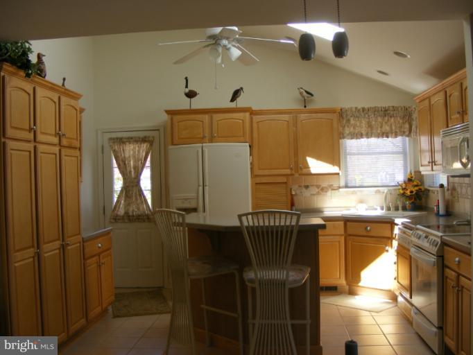 174 River Road Pasadena, MD 21122 - Photo 8 of 28 a kitchen with a sink a refrigerator and cabinets
