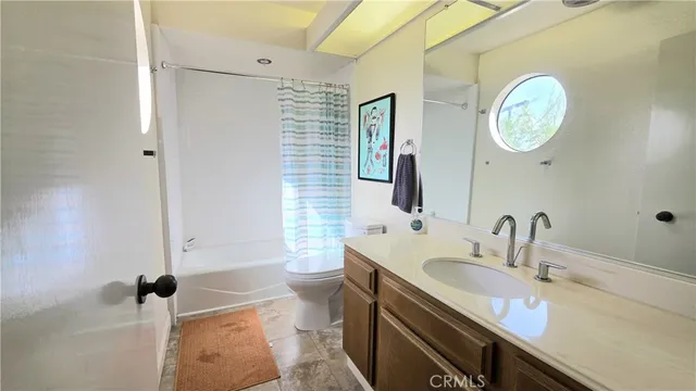 a bathroom with a granite countertop sink mirror vanity and toilet