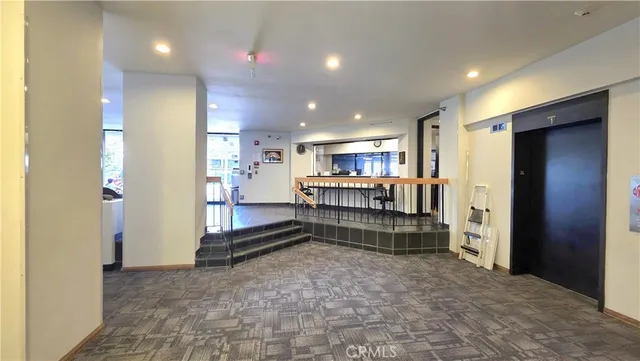 a large space with stainless steel appliances kitchen island granite countertop a refrigerator and a sink