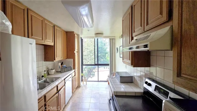 a kitchen with stainless steel appliances a stove a sink and a refrigerator