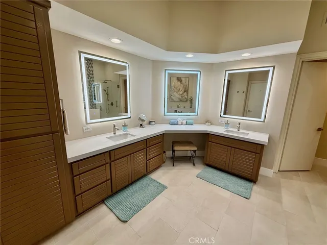 a bathroom with a tub double vanity sink and a window