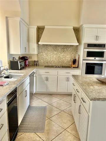 a kitchen with granite countertop a sink stove and cabinets