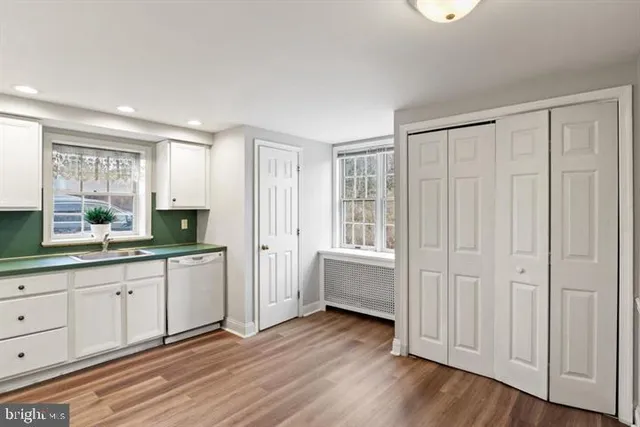 a kitchen with white cabinets and white appliances